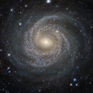 Spiral galaxy ngc 6814 with luminous arms, a glowing core, and dark dust streaking throughout the arms