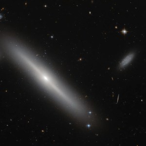 Big, bright disk galaxy next to small irregular galaxy