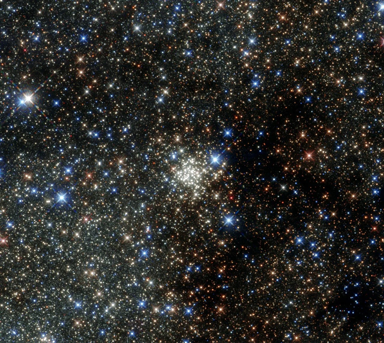 A field of stars of a variety of colors on a black background