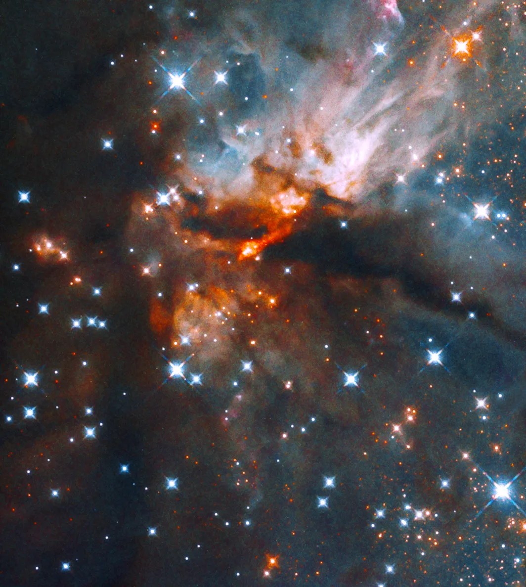 Blue and white, orange-red nebula bisected by a dark nebula, image is dotted with blue-white stars