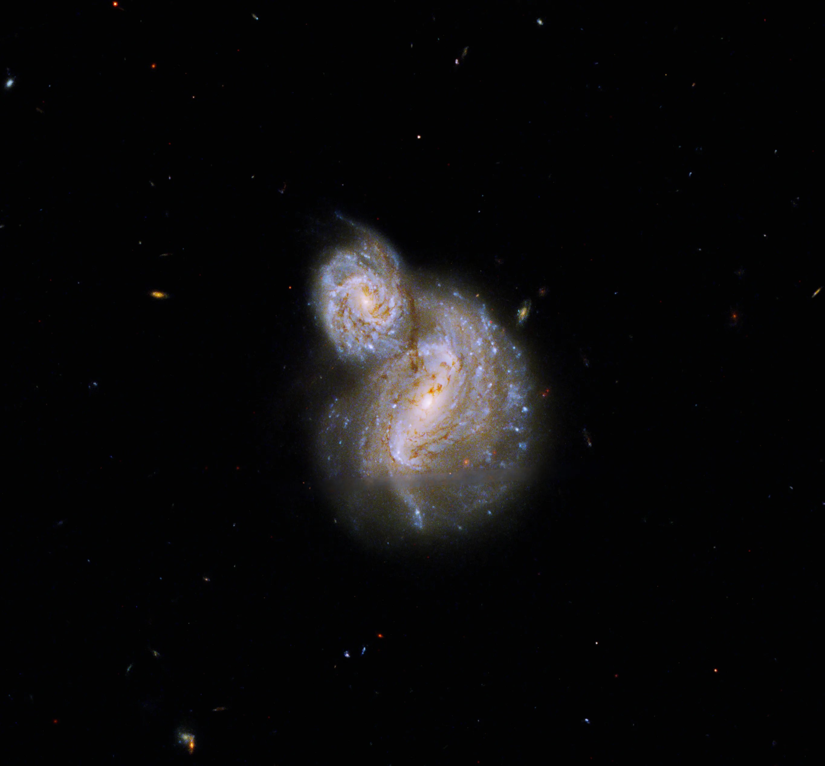 Two, face-on spiral galaxies. the larger one is centered in the image. the smaller one is superimposed on the upper left side of the larger.