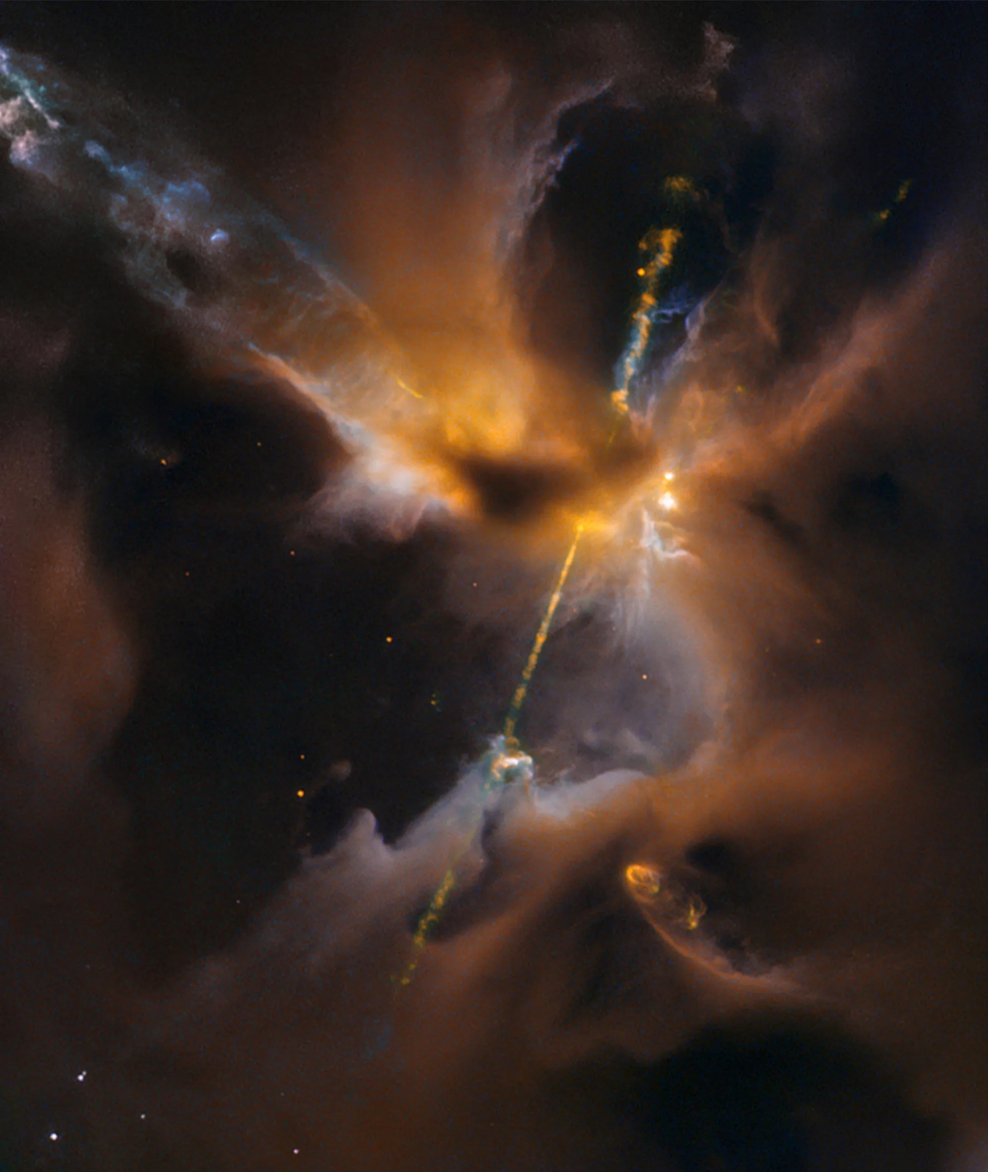 An orange and blue jet of material slashes diagonally through caverns of orange and gray colored gas and dust.