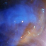 Hubble image of a reddish-orange stellar jet against the bright blue nebula.