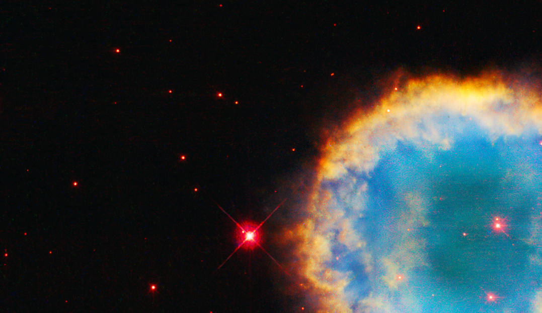 right side of image: circular nebula with reddish-white star at center, turquoise interior with hazy, cloudy yellow-orange and red rings around the center