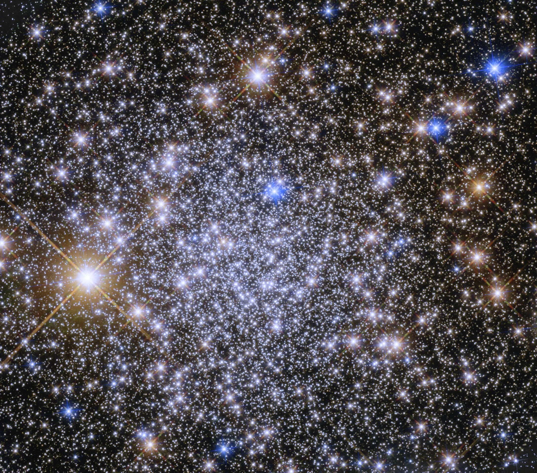Bright blue-white stars fill the scene with a smattering or bright yellow-white stars