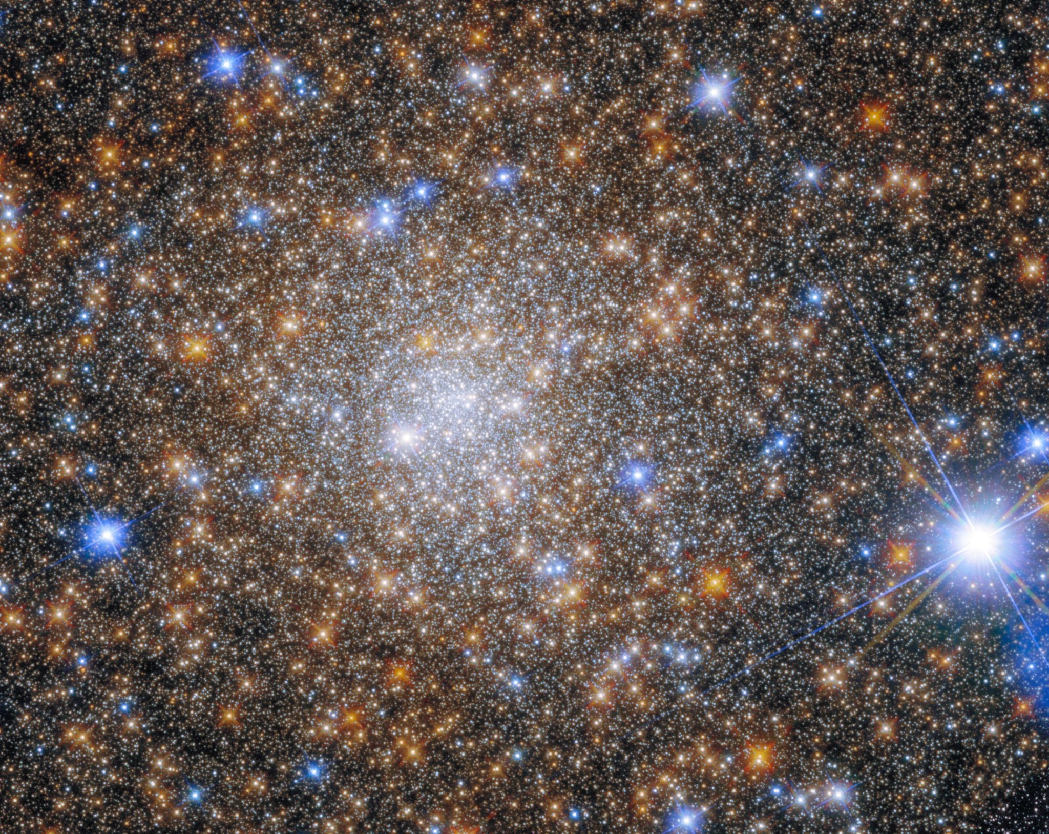 A field of blue-white, reddish-gold, and white stars fills the view