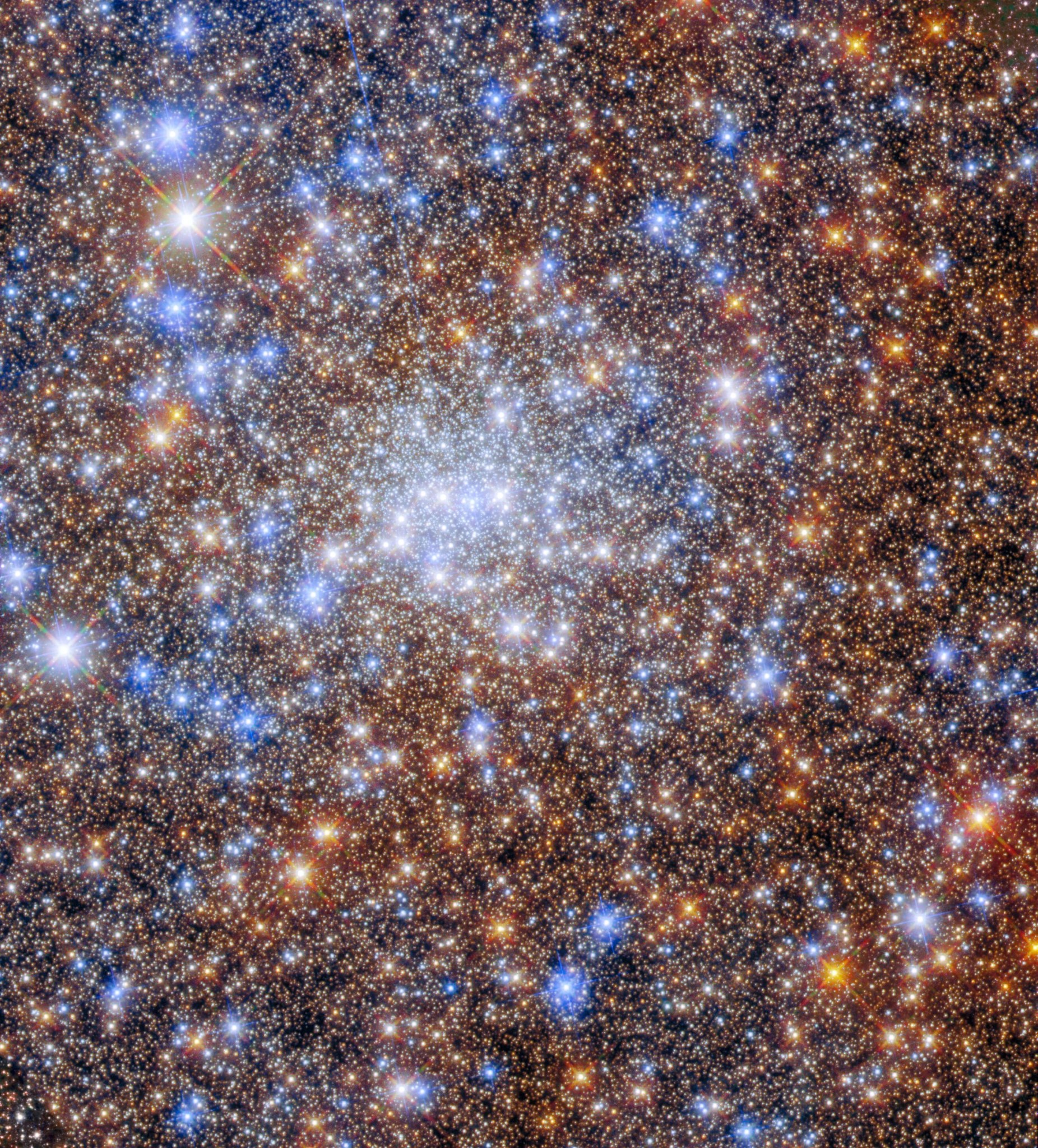 reddish-gold fill the scene, bright blue-white stars dot the scene, bright white stars fill the center of the image