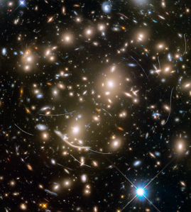 A galaxy cluster that is lensing more distant galaxies into arcs. Curved S-shaped trails of asteroids.