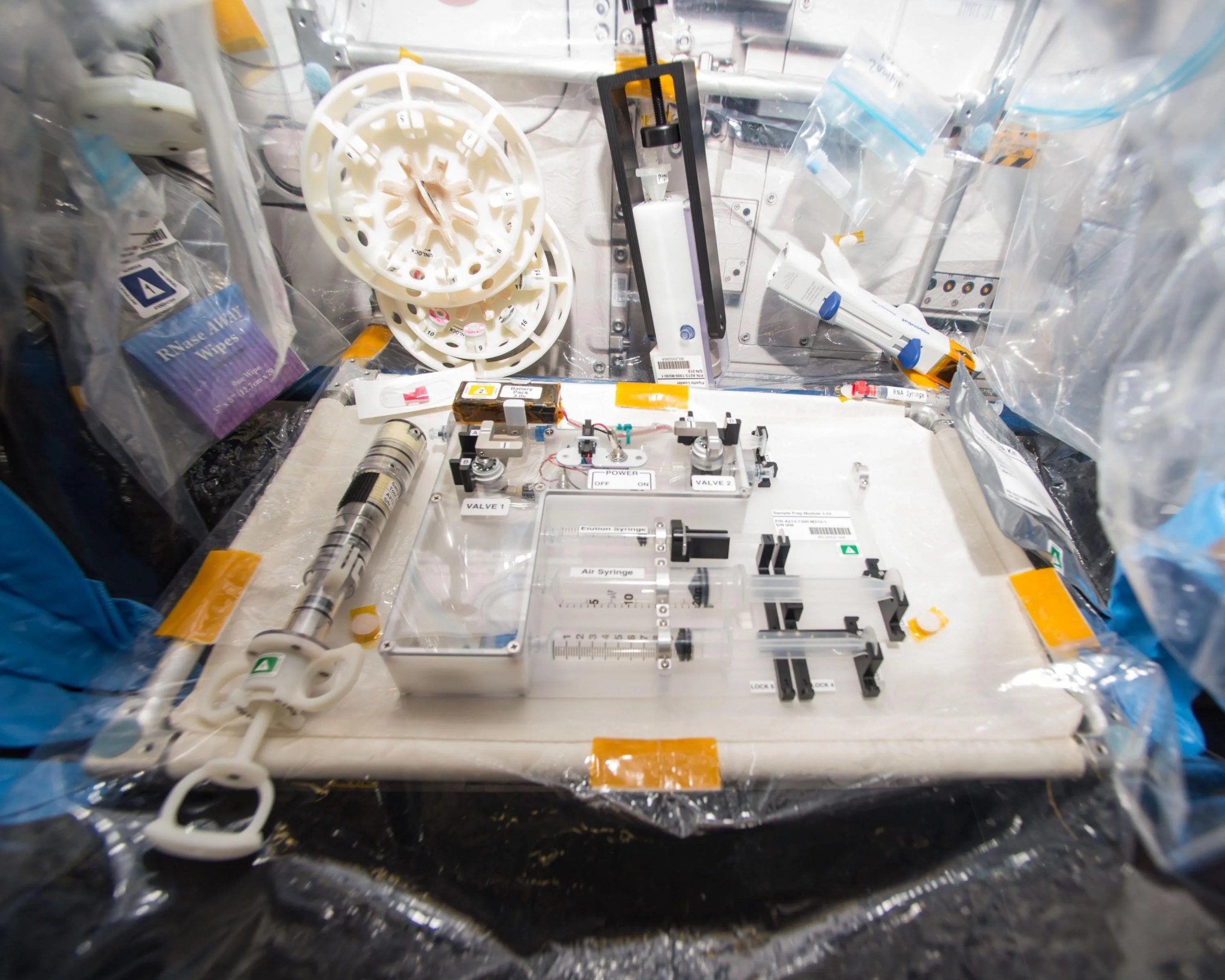 Lab with test equipment comprised of syringes, plastic containers, and other apparatuses.