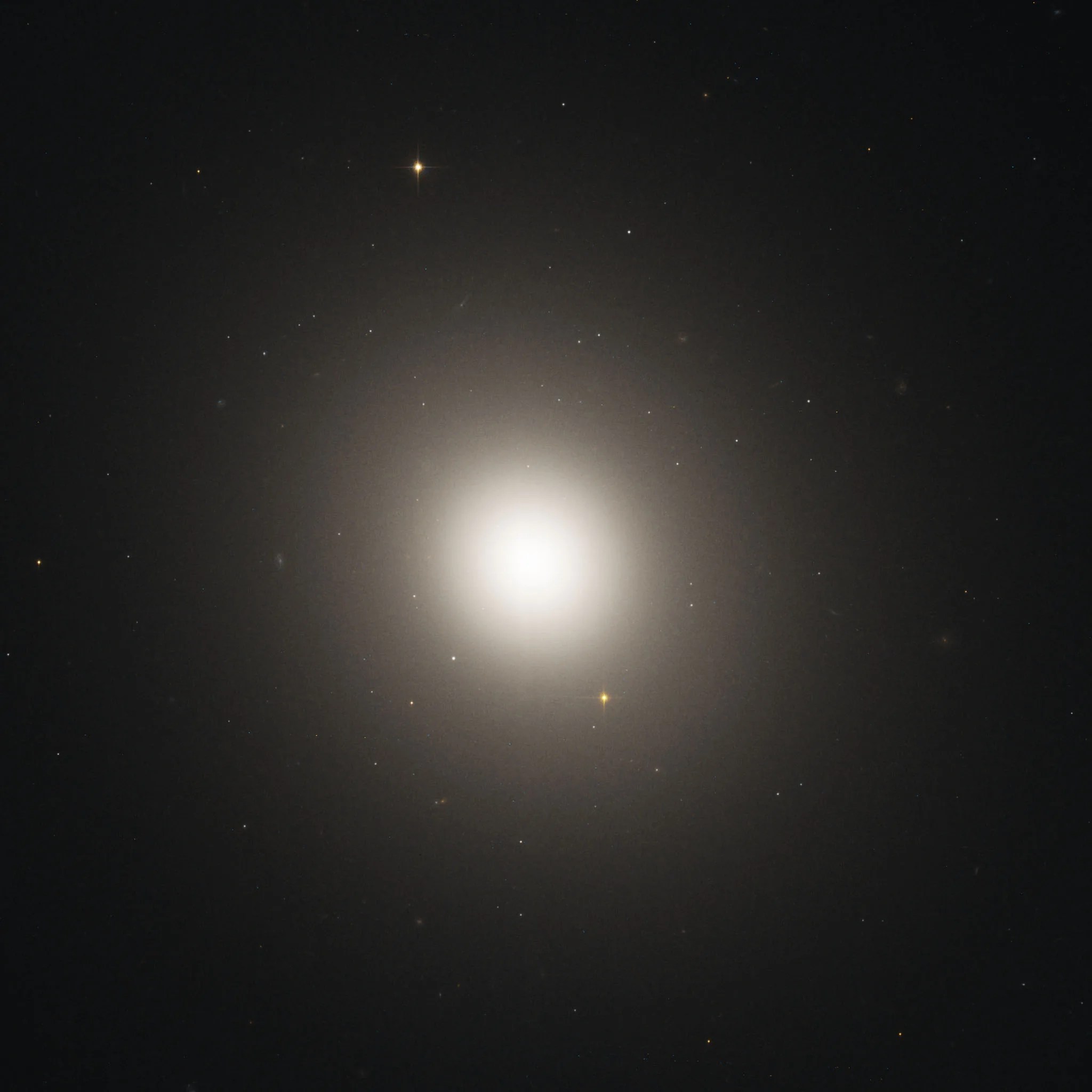 A hazy white-yellow light shines against black space, dotted with faint, distant stars.