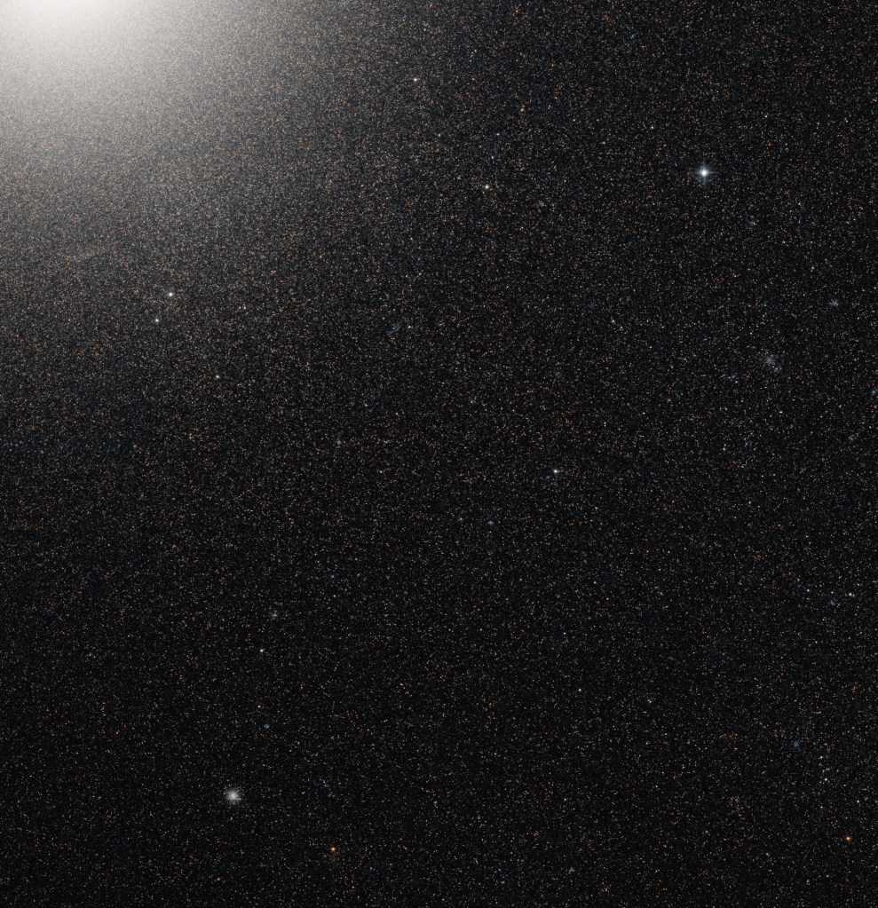 thousands of stars can be seen in the corner of a galaxy that is void of gas and dust.