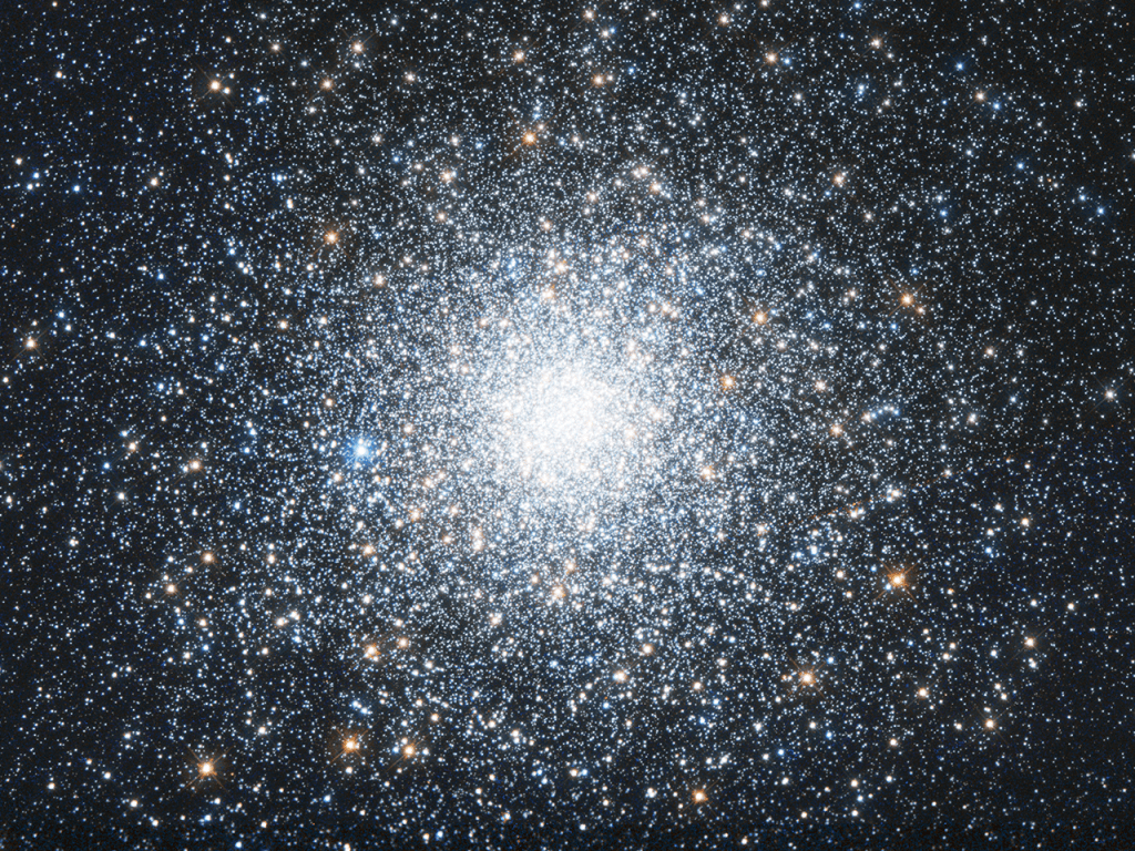 A bright cluster of white and orange stars, concentrated more densely at the center.