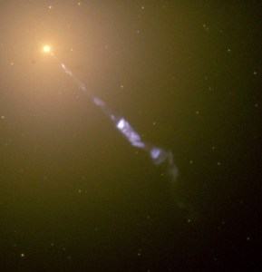 This close-up image shows a jet of material ejecting down and to the lower left corner from a bright, orange-ish galaxy core.