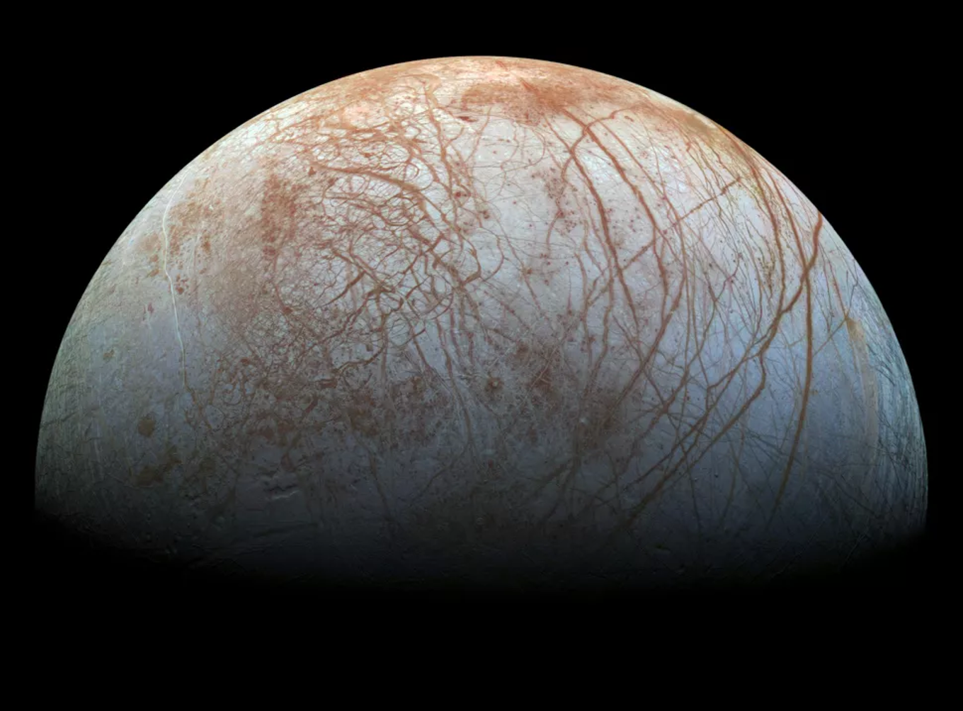 Photo of Jupiter's moon Europa, light grey with brown streaks.