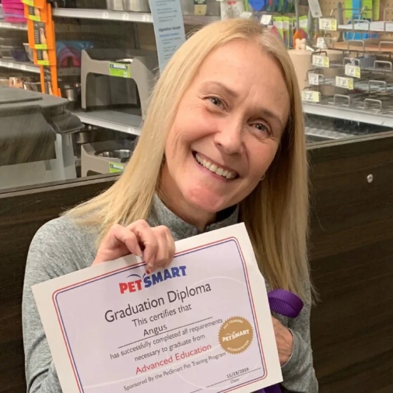 Melissa A. Morris holding a PetSmart graduation diploma.