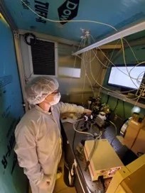 Photo of a research scientist in lab wearing protective gear