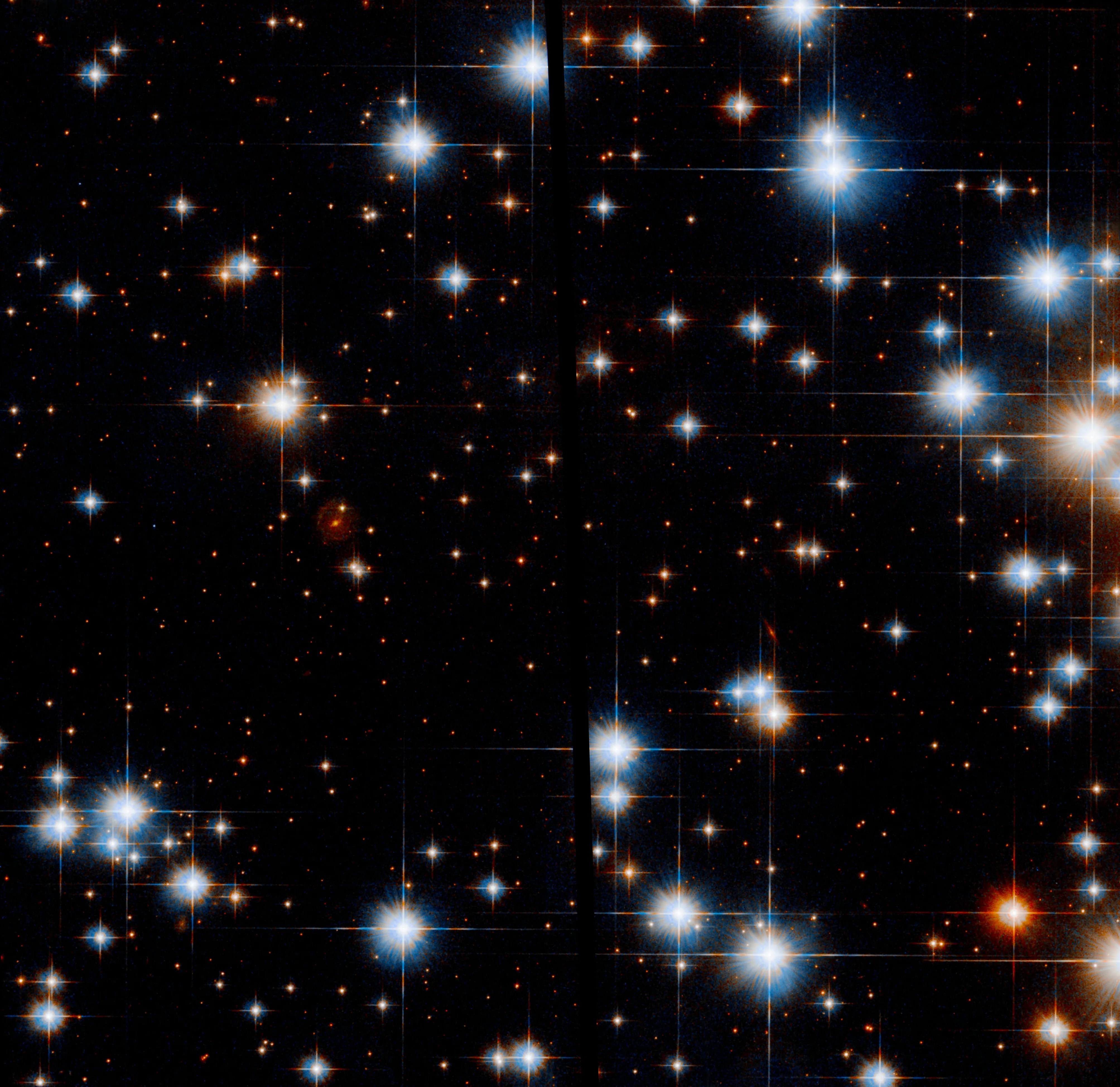 Several very bright stars are scattered throughout the field of view, with many fainter ones behind them. Most of the brightest stars are bluish-white, while the rest have a reddish-orange hue, and some slightly-less-bright stars are deep red.