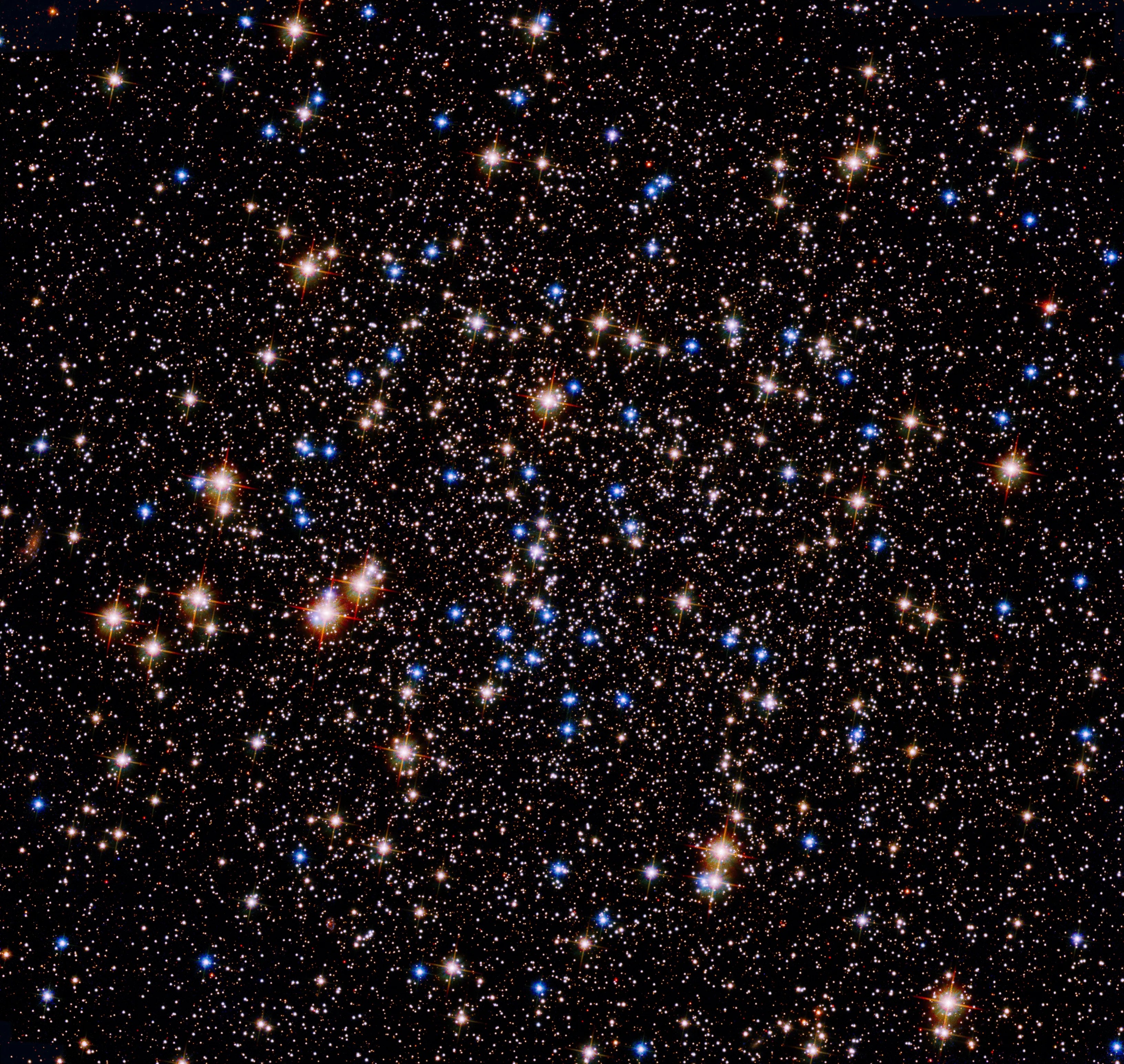 A grouping of blue and reddish stars against the black background of space.