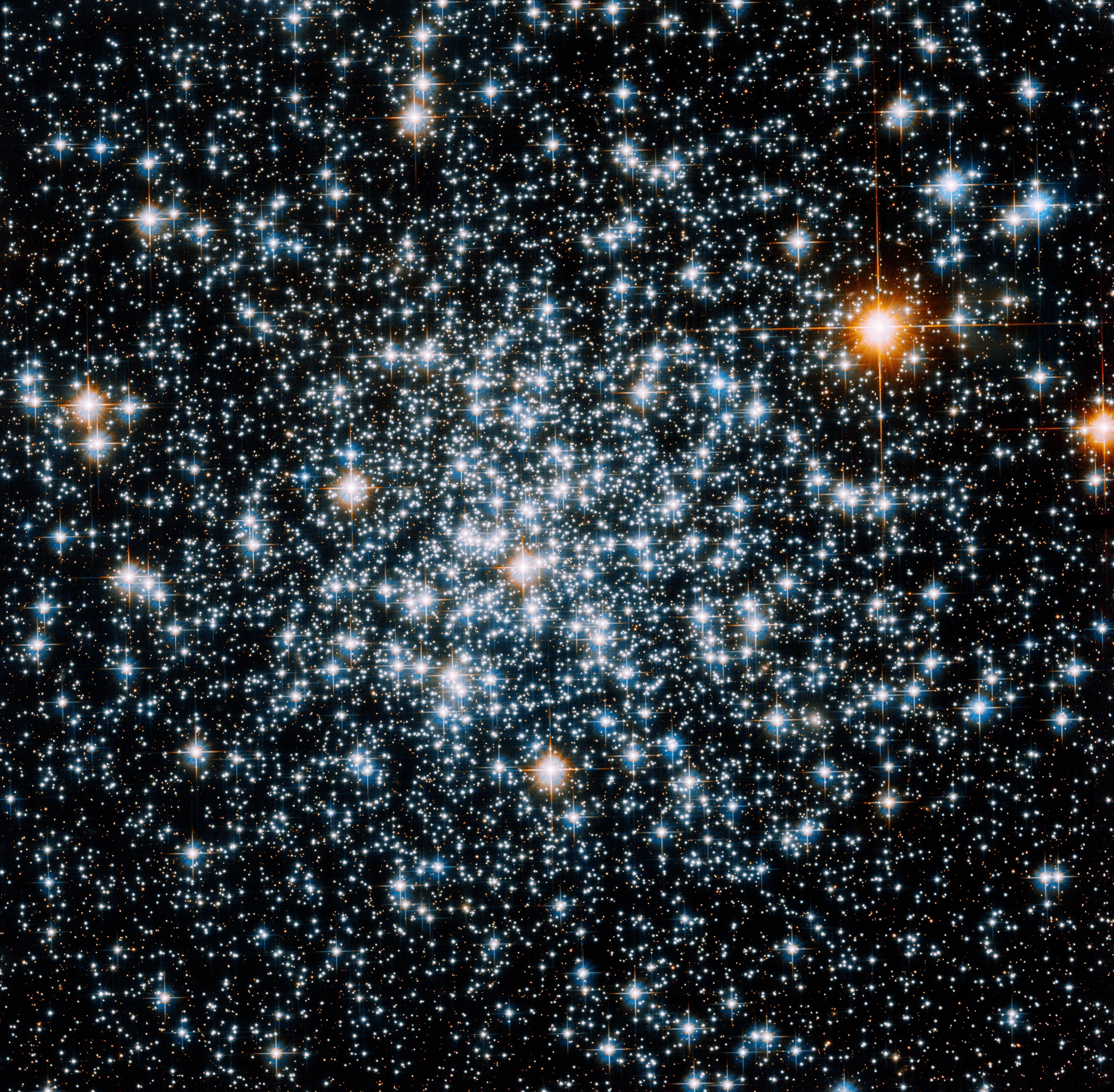 A grouping of mostly blue and white stars with two bright red stars to the right.