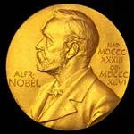 A circular, gold Nobel Prize Medal sits against a black background.