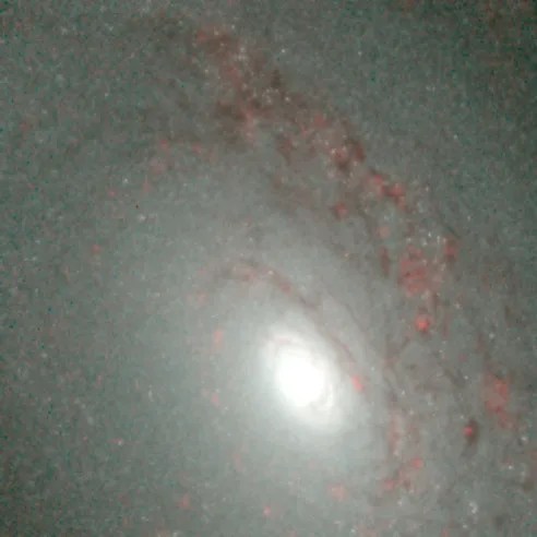 A bright galaxy core shines near the lower center of the image, surrounded by hazy, dusty spiral arms.