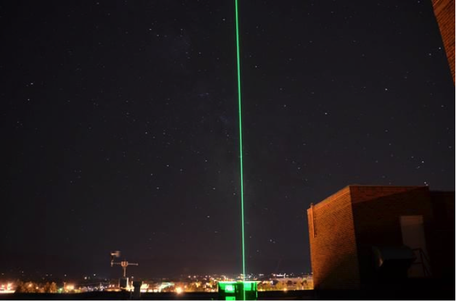 Two lidar beams look up into the sky from the roof of the optical remote sensing laboratory at Montana State University in Bozeman, Montana, USA. The visible green laser beam is measuring the atmospheric profile of aerosols and clouds, while the invisible infrared laser beam is measuring water vapor. The lidars are in a laboratory on the top floor of the engineering building and transmit to the atmosphere through a roof port hatch. Credit: NASA/A. Nehrir.