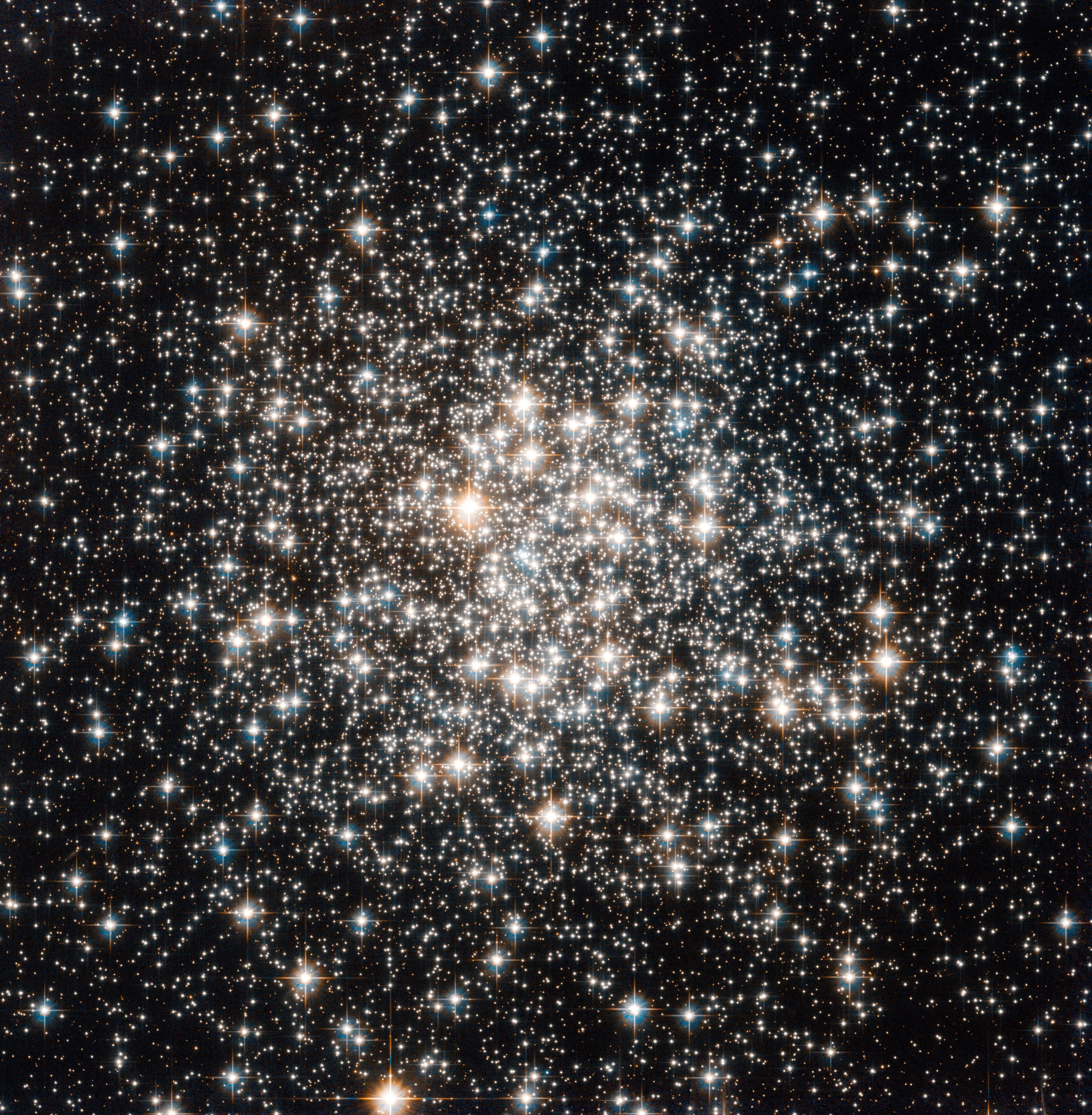 A bright cluster of white and yellow stars against black space.