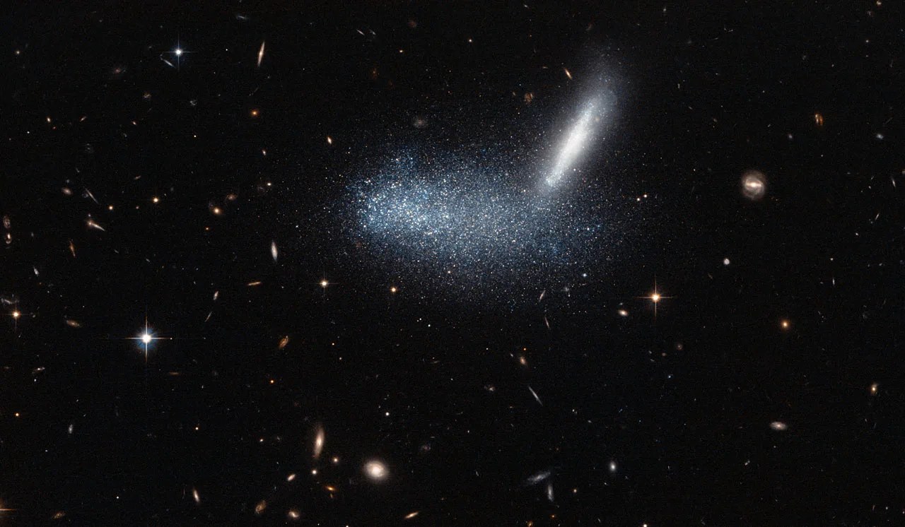 A starfield, centered on a horizontal blur of bluish light and bright streak up to the right