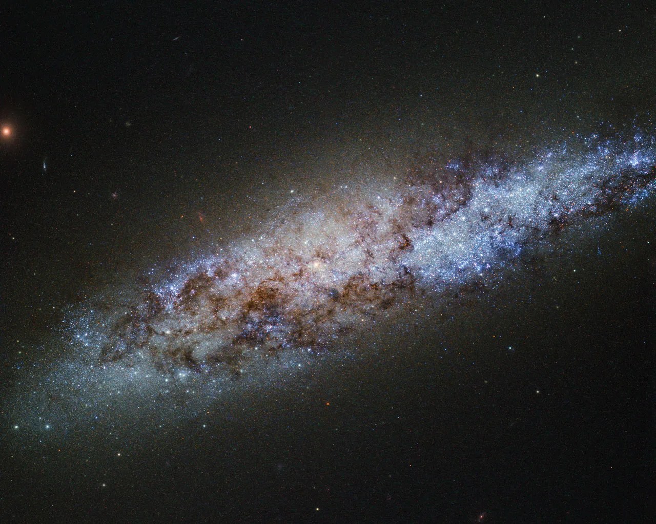 Bright blue stars and dusky red dust lanes in a diagonal streak