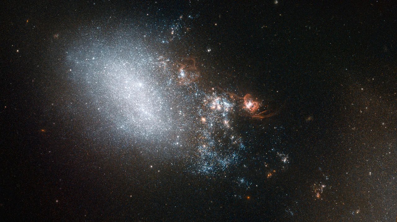 A soft blur of a galaxy, bordered on the left by explosions and bright starbursts