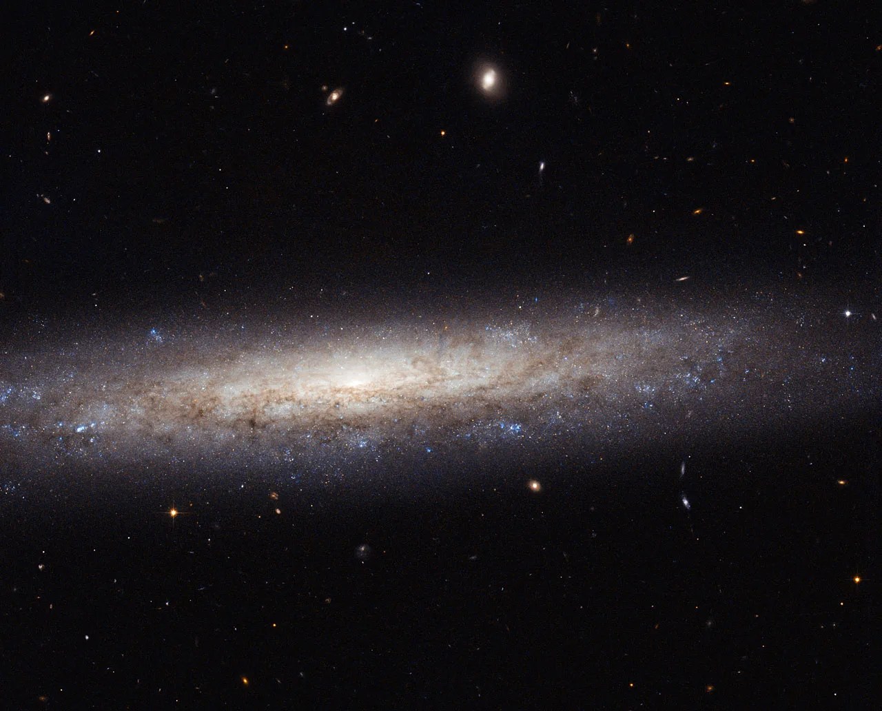 Dusty streak of a spiral galaxy on a black starfield