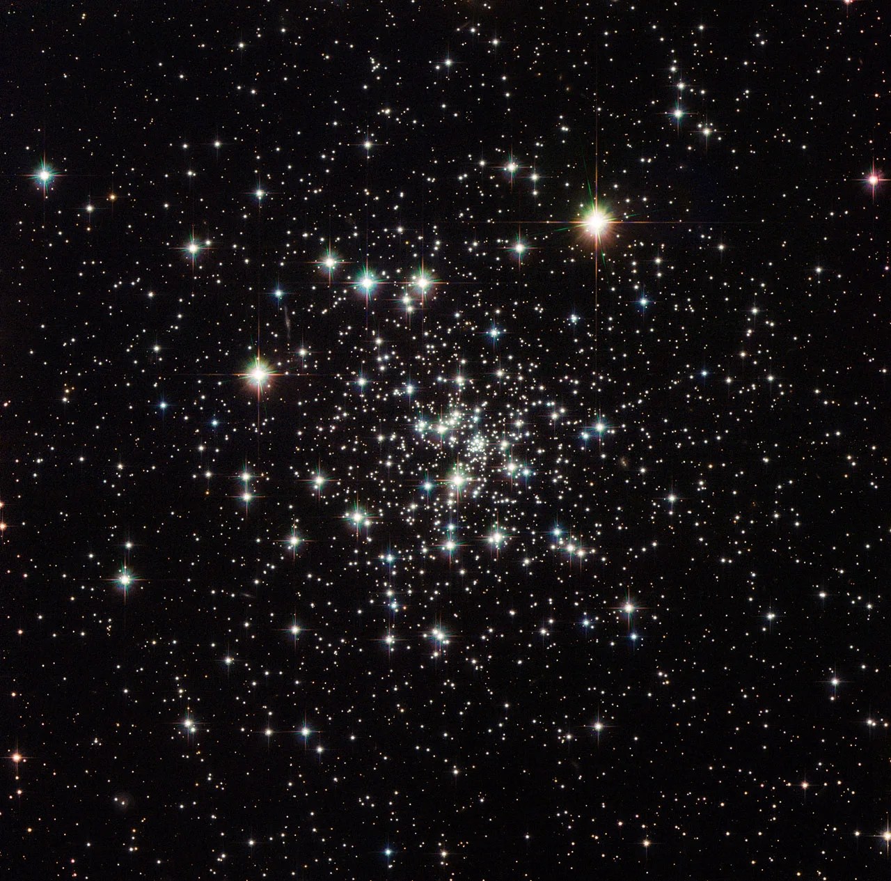 A loose concentration of a multitude of bright white stars on a black background, with the higher concentration of stars toward the center of the grouping.