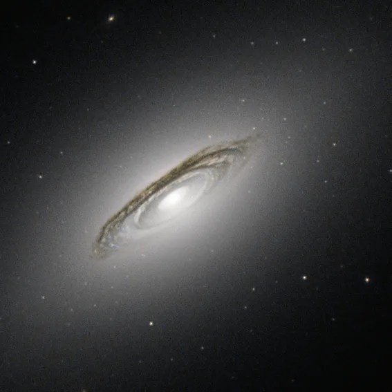 A tilted, disk-shaped galaxy with a bright core and dark dust lanes against the black background of space.
