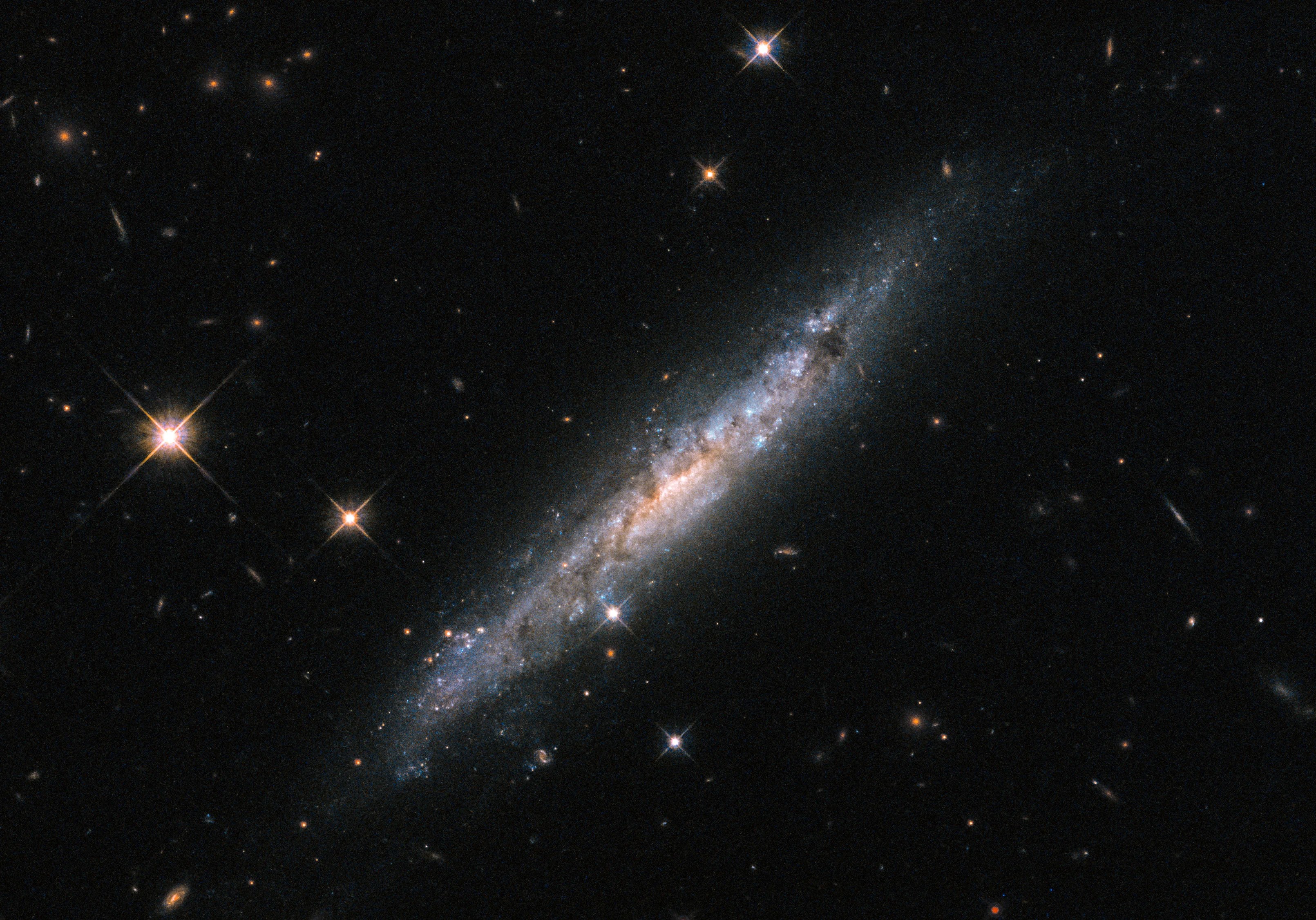 Diagonal edge-on galaxy with bright scattered foregeround stars