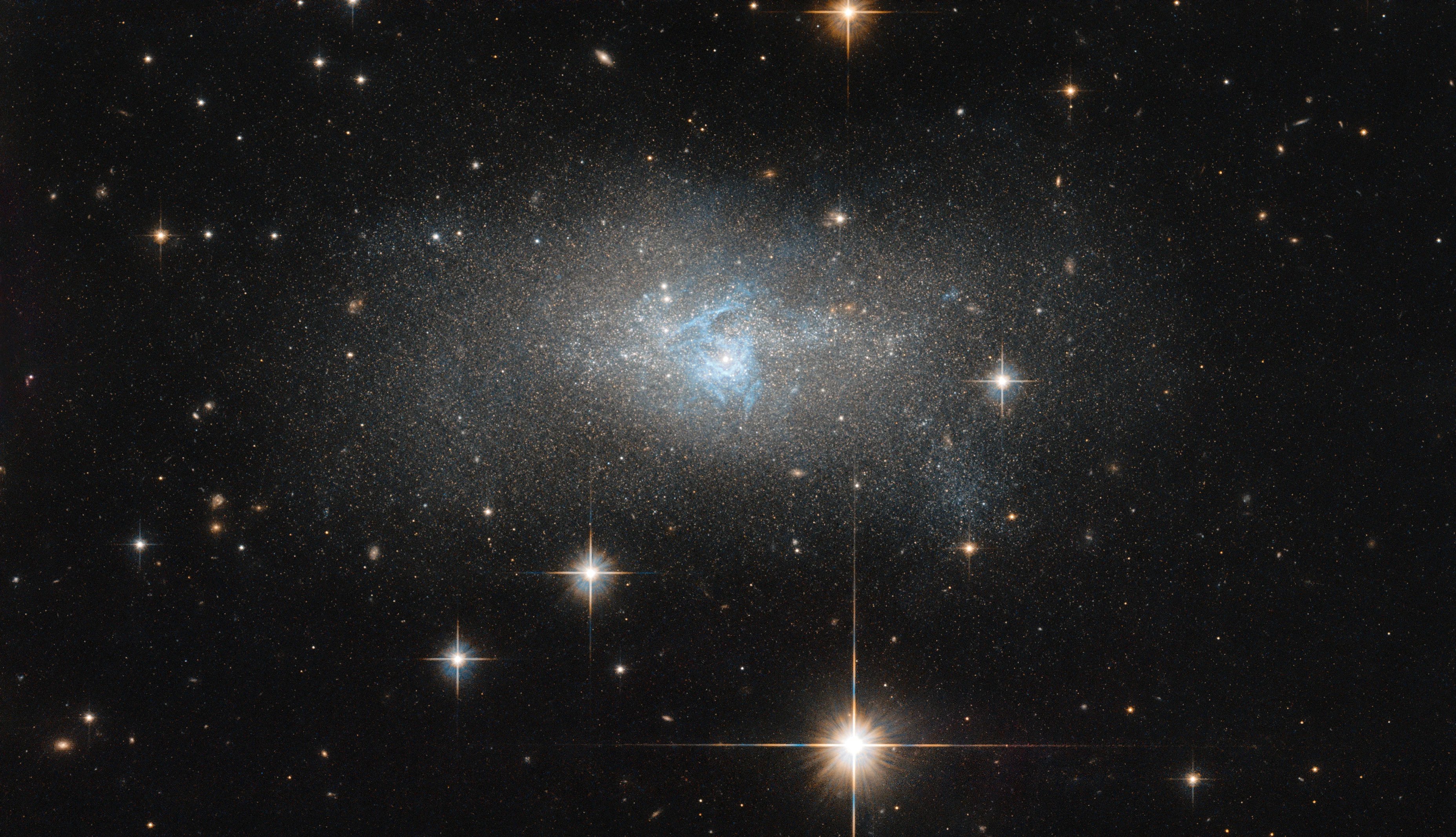 Diffuse galaxy with wispy blue threads at center