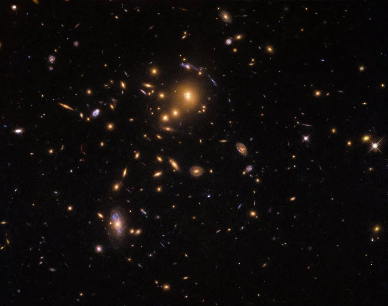 An upper left cluster of orange galaxies with a few blue streaks around them
