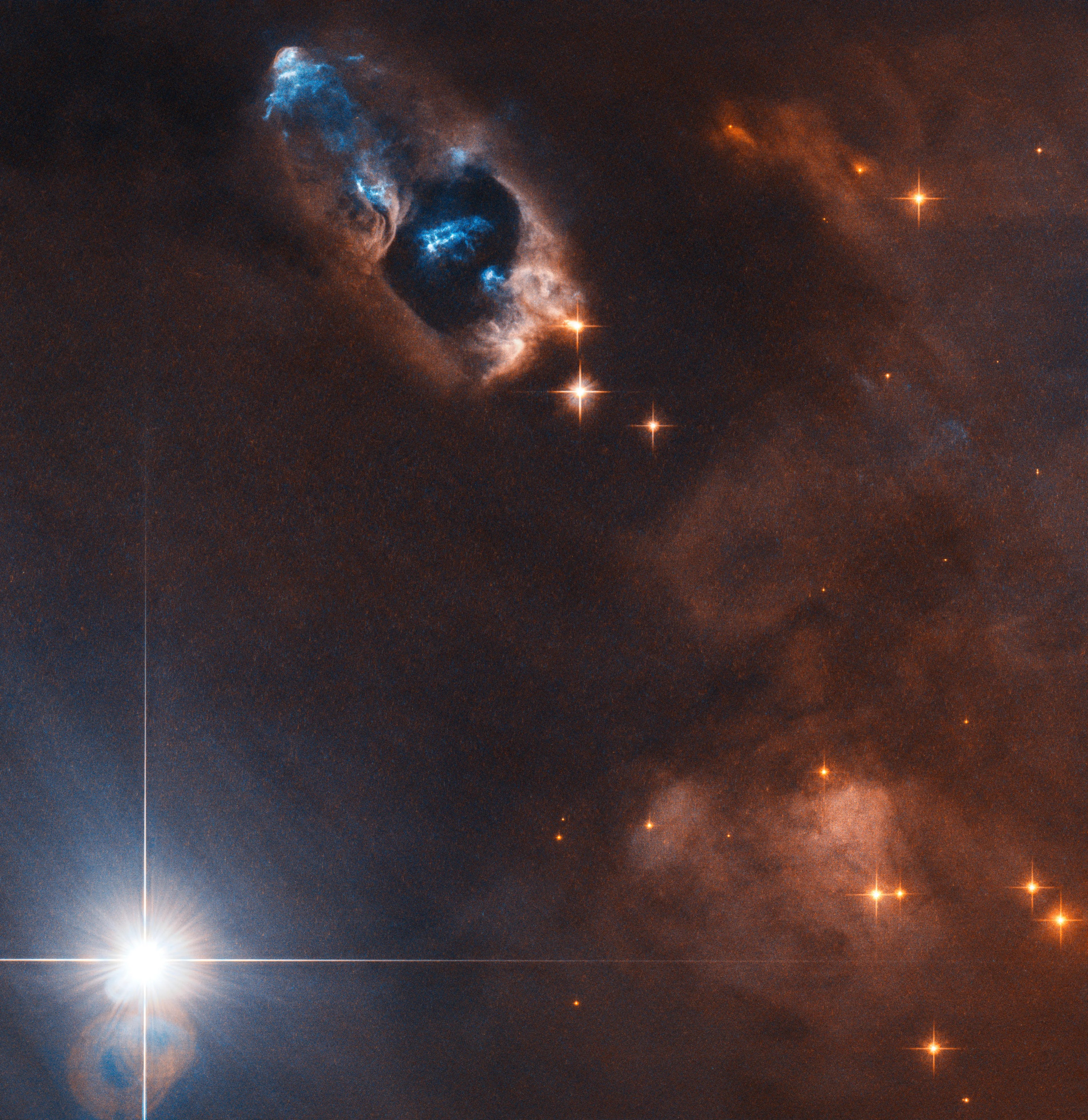 Bright objects pierce a hole in a ruddy nebula