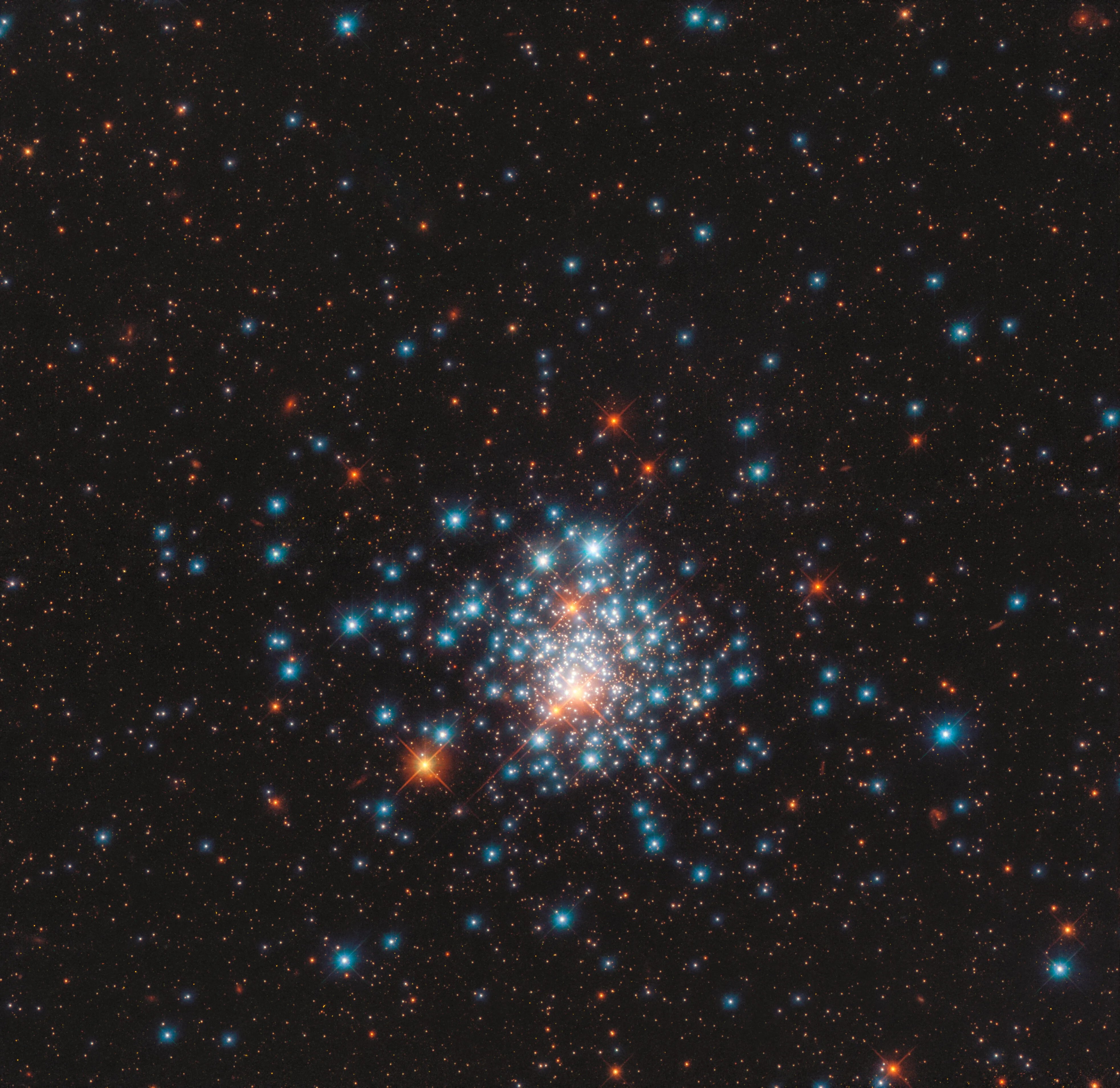 Cluster of blue- and red-hued stars against the black backdrop of space