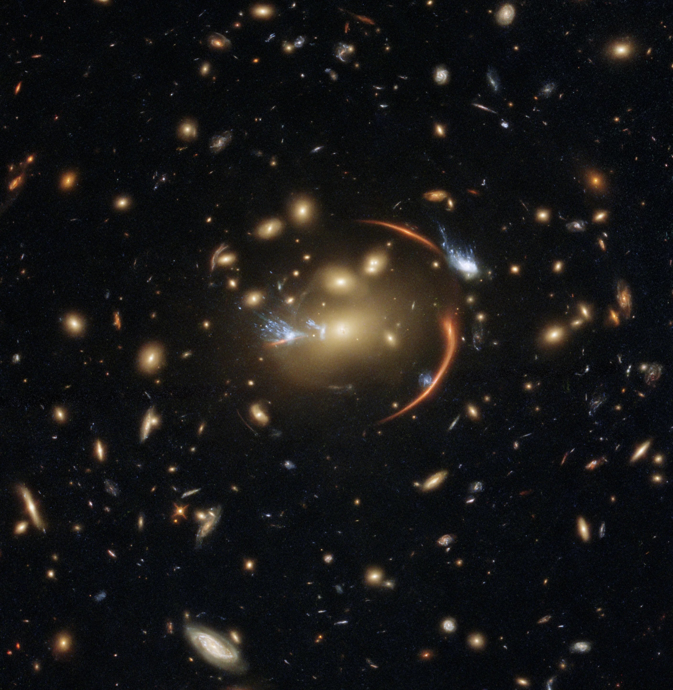 The center of this image from the nasa/esa hubble space telescope is framed by the tell-tale arcs that result from strong gravitational lensing.