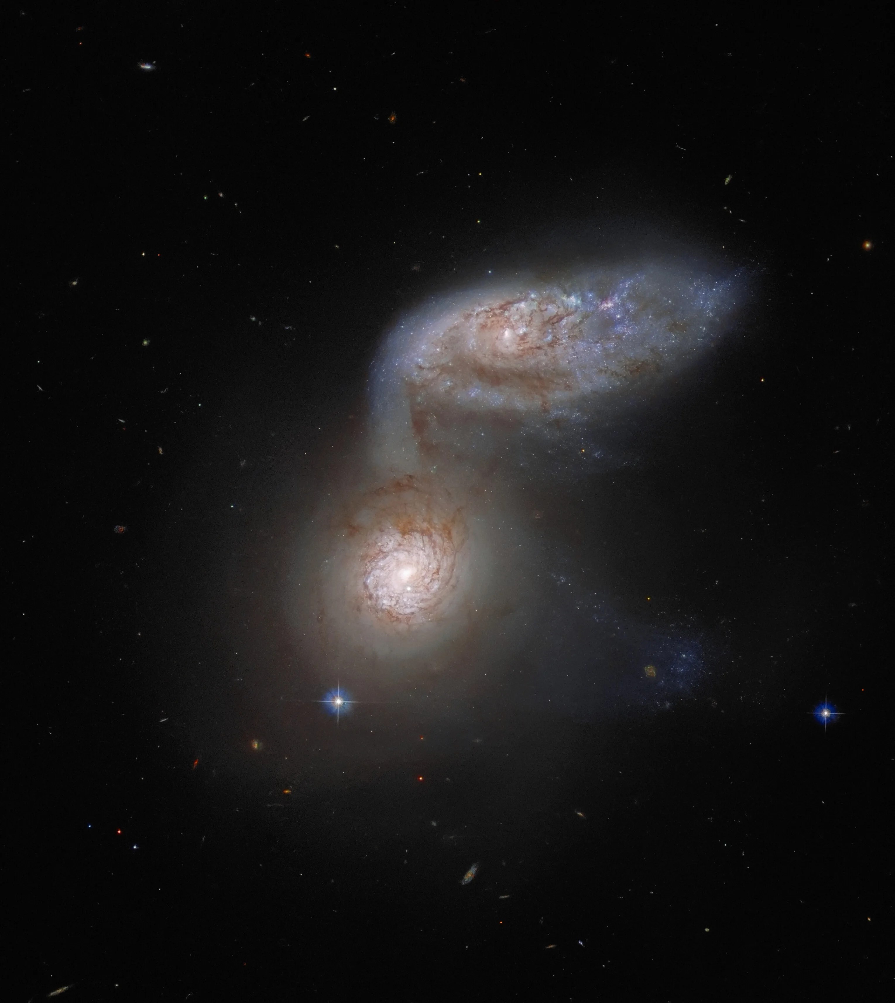 This nasa/esa hubble space telescope image features two interacting galaxies that are so intertwined, they have a collective name – arp 91. their delicate galactic dance takes place more than 100 million light-years from earth.