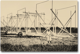 An old photograph of Karl Jansky standing in front of his radio telescope.