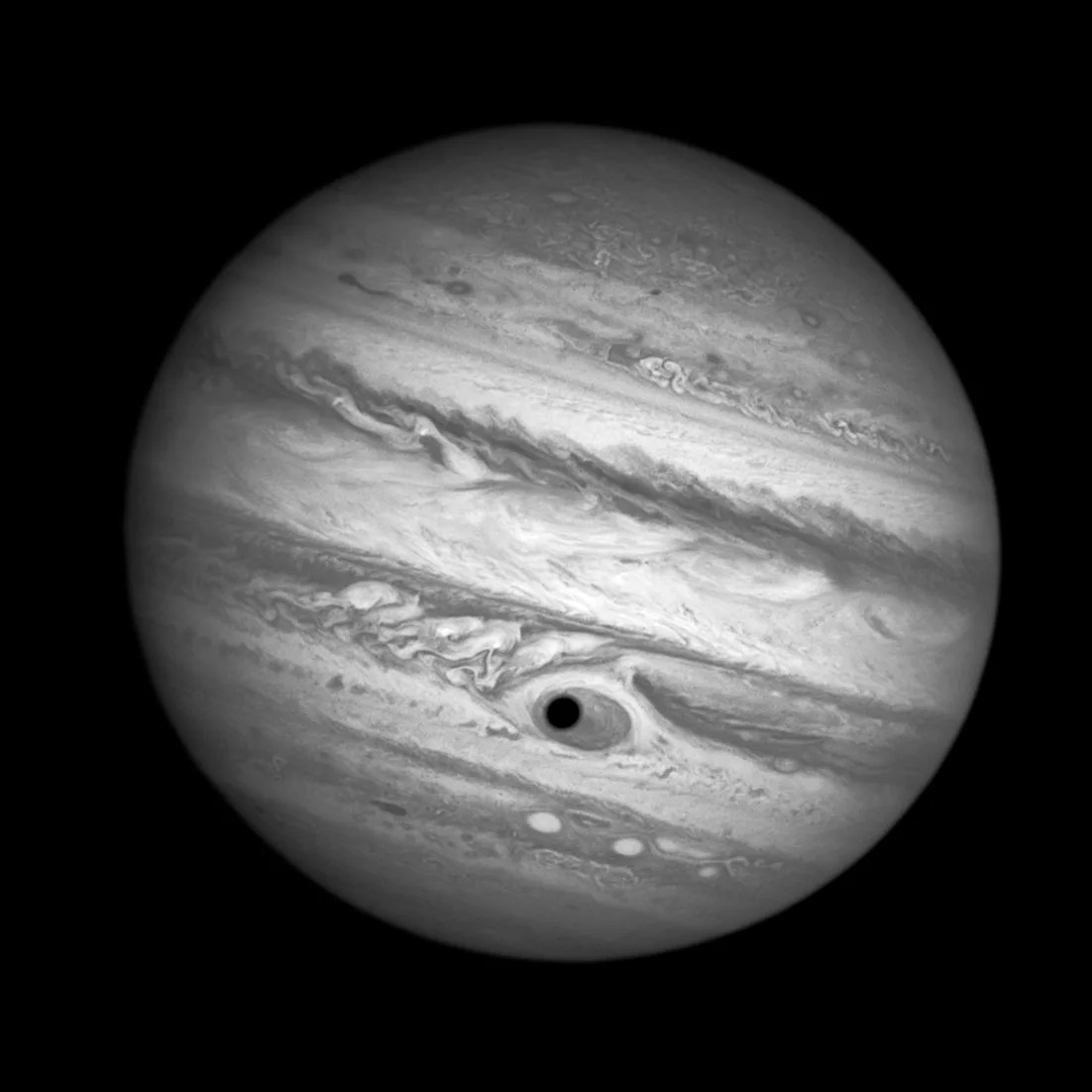 Jupiter with its moon Ganymede's shadow forming the dark pupil of an eye with the great red spot as the iris.