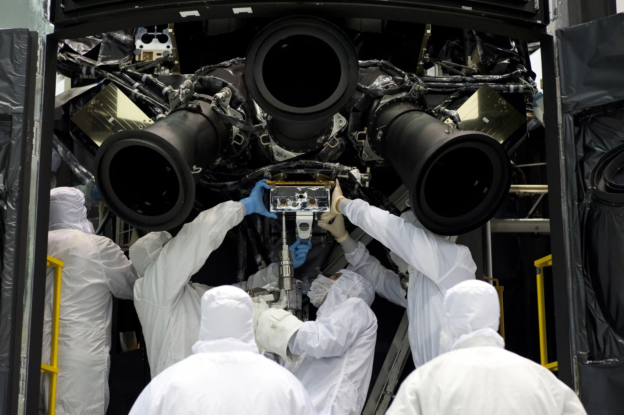 photo of astronauts practicing the installation of a rate sensor unit on Hubble mock-up