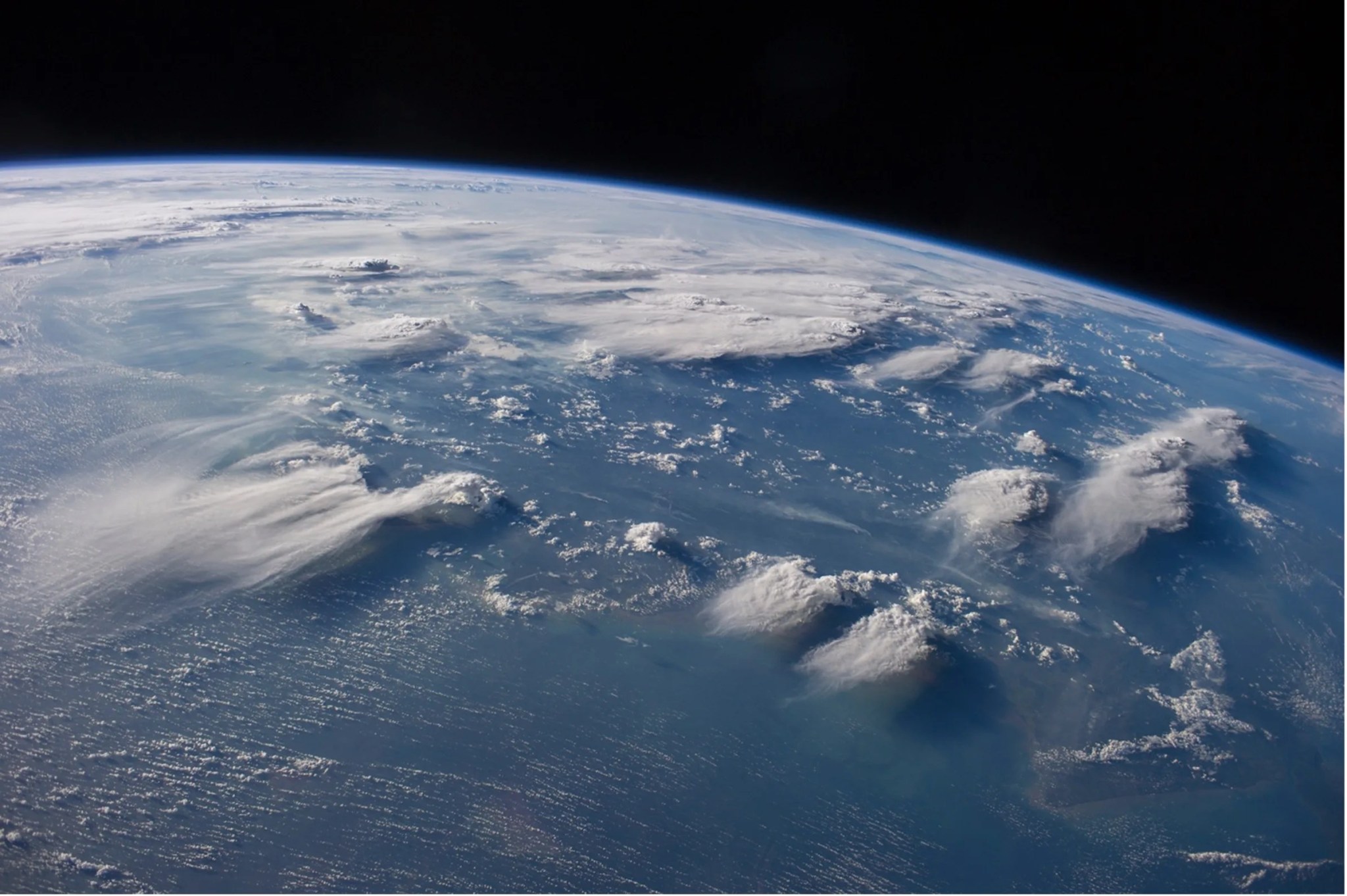 Satellite photo of thunderstorms scattered over a blue area on planet earth