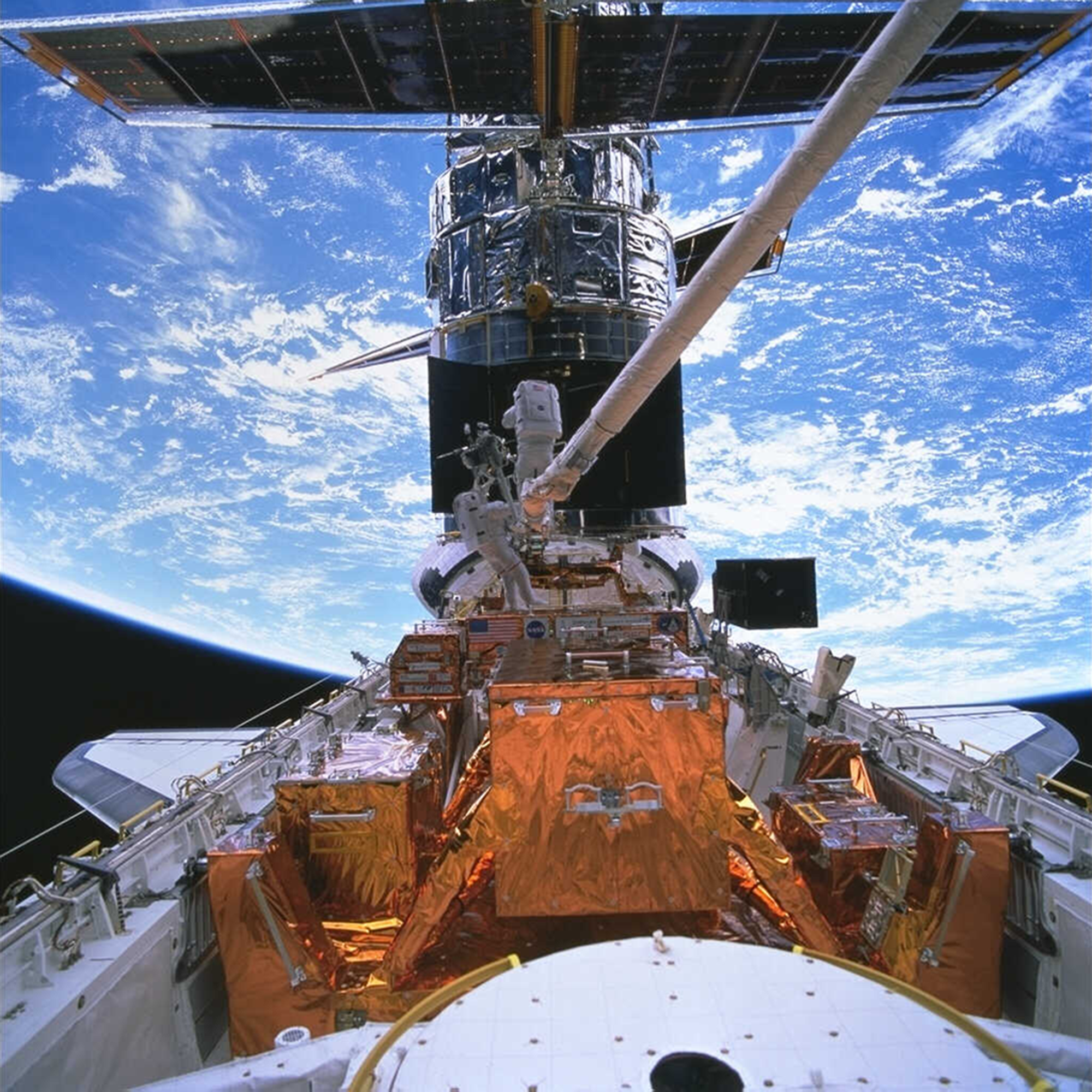 Astronauts in space with hubble