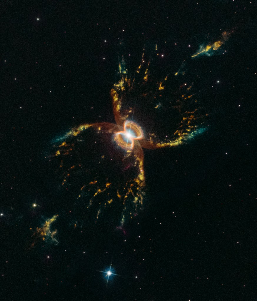 X-shaped nebula in colors of green, yellow, and rusty brown