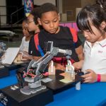Young students looking at a robotic project
