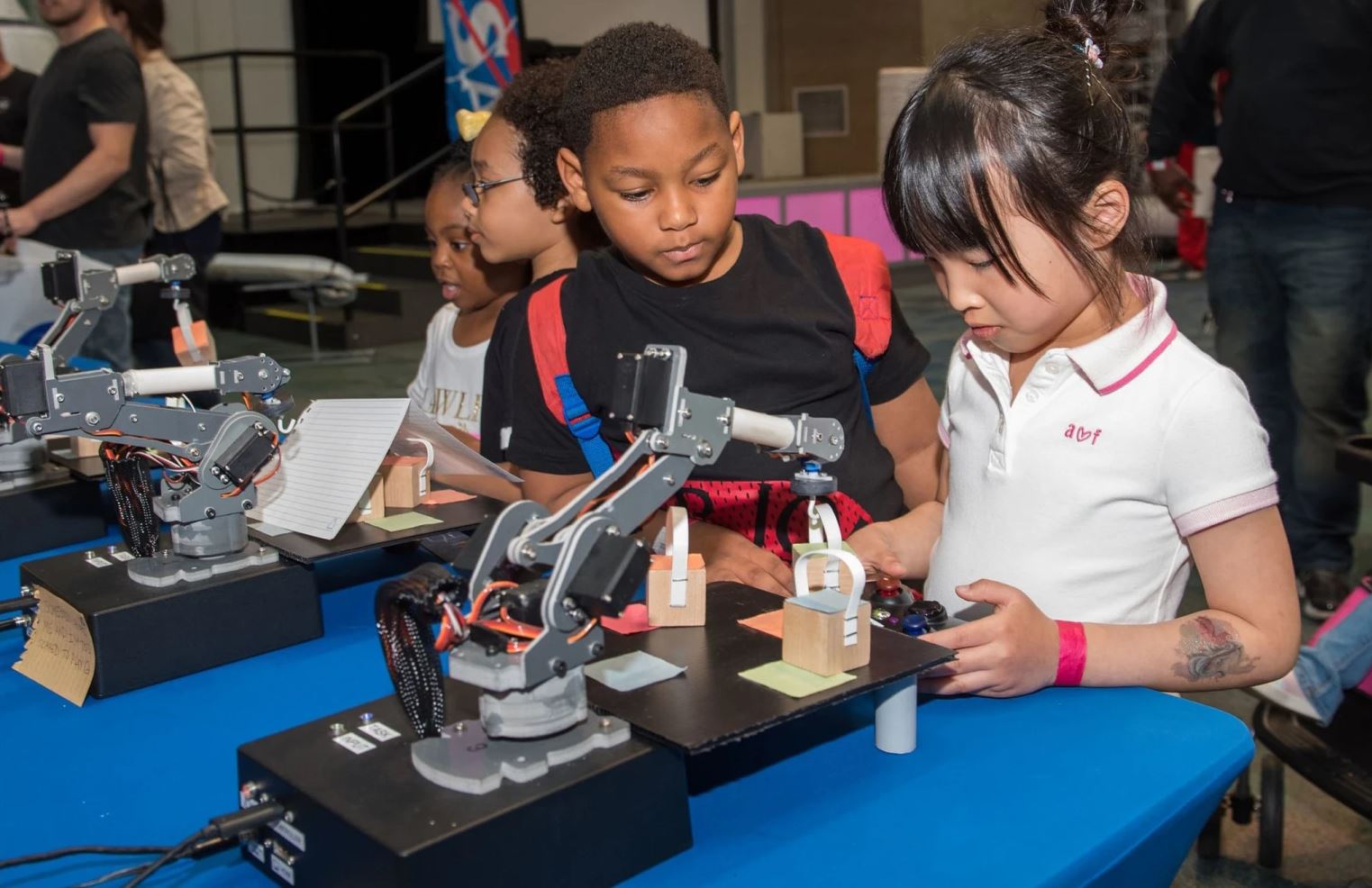 Young students looking at a robotic project