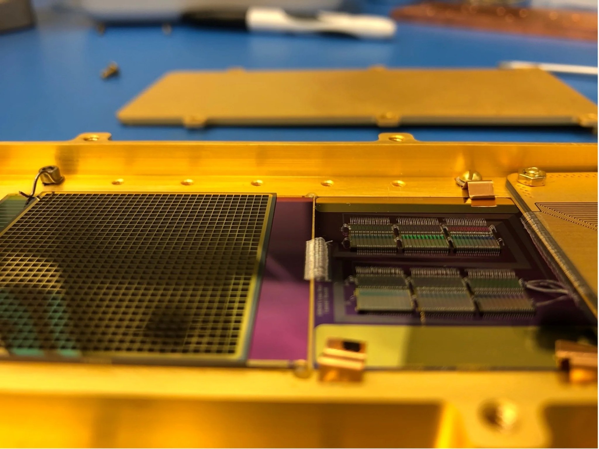 Close up photo of a gold metal panel with a grid detector on the left and 6 small rectangular multiplexors on the right