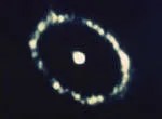 A bright circle in the center of a broken, oval ring.